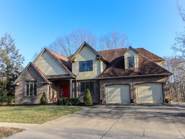 view of front of property with driveway, a front lawn, an attached garage, and brick siding