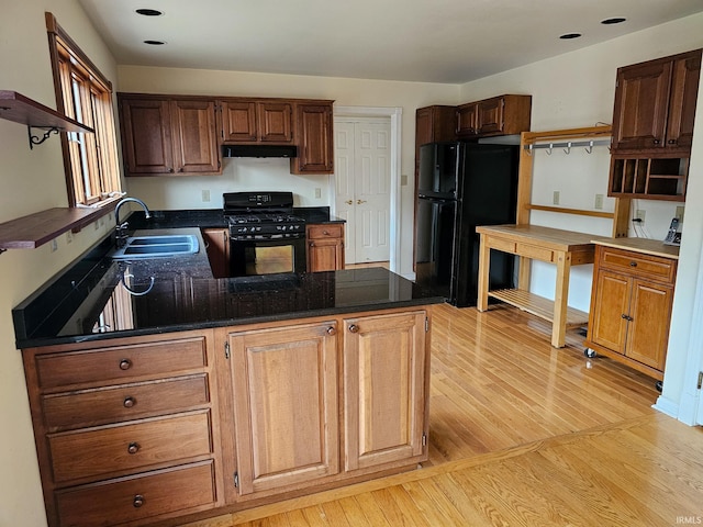 kitchen with open shelves, a sink, a peninsula, under cabinet range hood, and black appliances