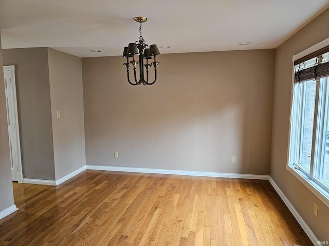 unfurnished room with light wood-style flooring, a wealth of natural light, and baseboards