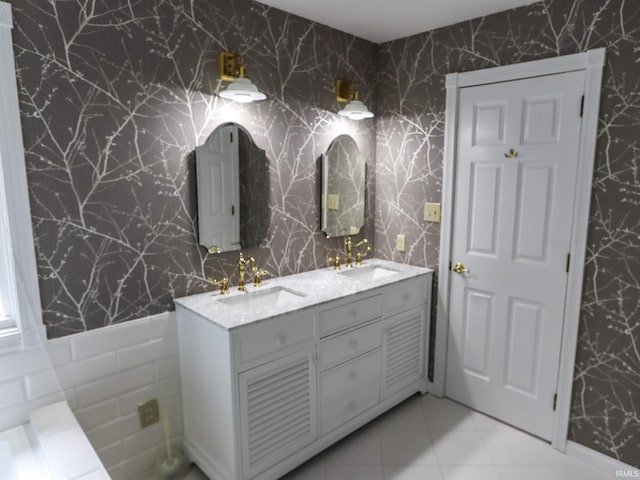 full bathroom with double vanity, a sink, and wallpapered walls