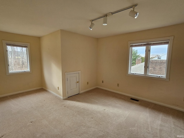 unfurnished room with light colored carpet, visible vents, and baseboards