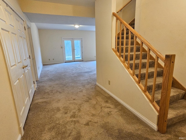 stairs with french doors, carpet flooring, and baseboards