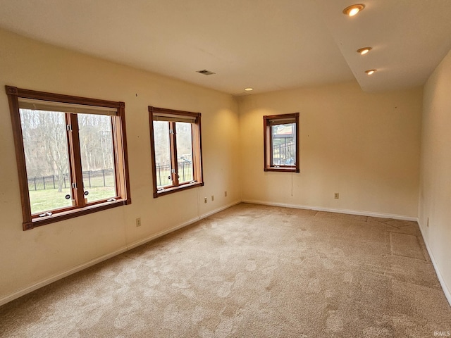 carpeted spare room featuring recessed lighting, visible vents, and baseboards