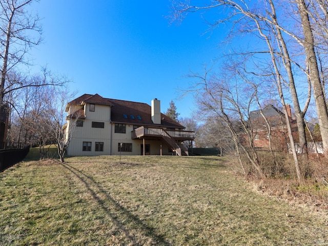 rear view of property with a chimney, stairway, a lawn, and a wooden deck