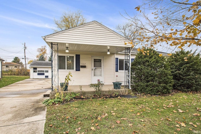 bungalow with a porch, a garage, an outdoor structure, concrete driveway, and a front yard