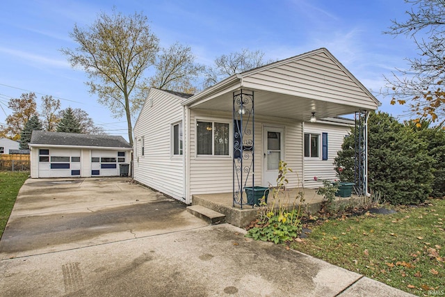 bungalow-style house with covered porch, a detached garage, and an outdoor structure