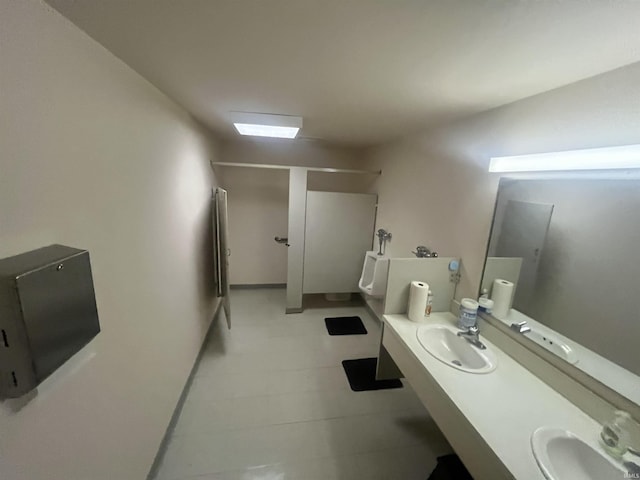 bathroom with double vanity, walk in shower, a sink, and tile patterned floors