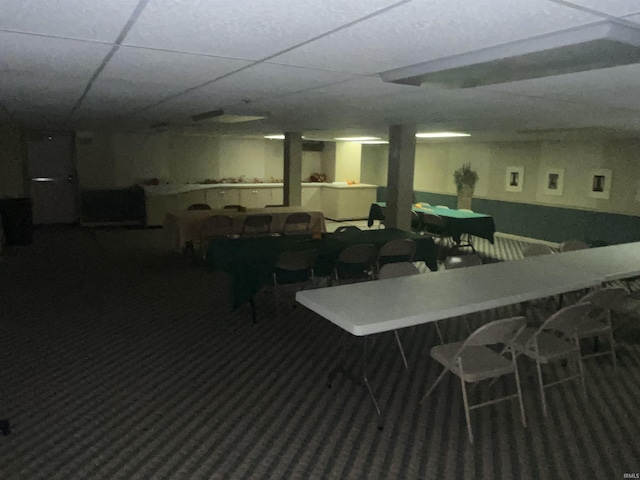 carpeted dining space featuring a drop ceiling