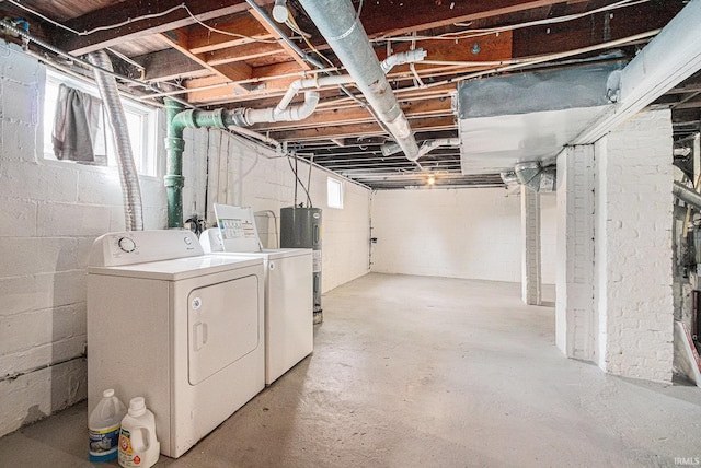 basement with electric water heater and independent washer and dryer