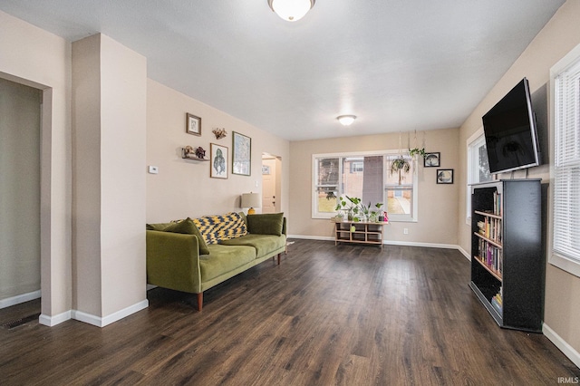 unfurnished living room with baseboards and wood finished floors