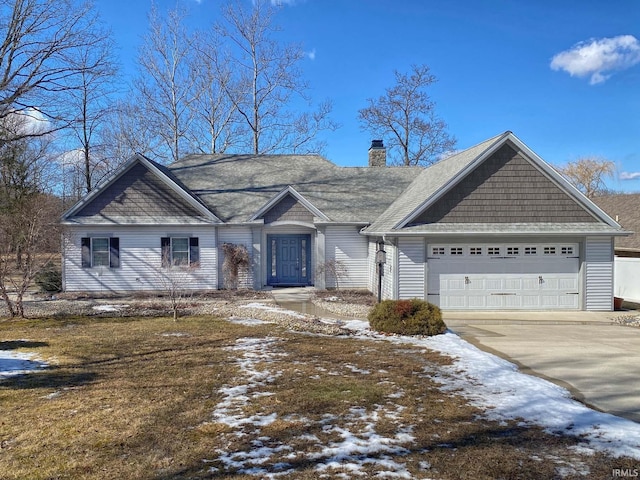 view of front facade with driveway, a chimney, and an attached garage