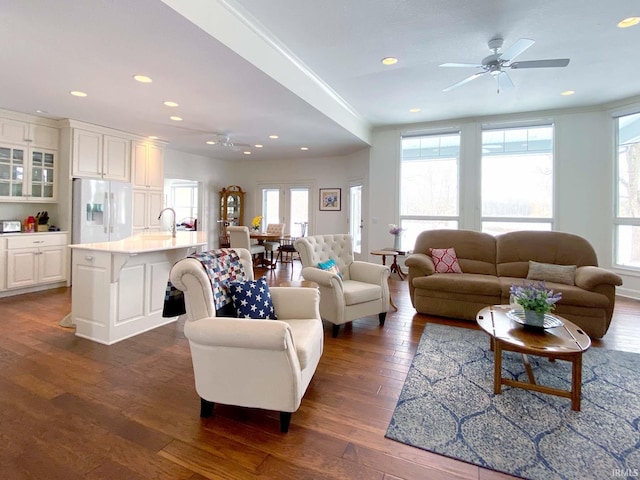 living area with a ceiling fan, recessed lighting, dark wood finished floors, and ornamental molding