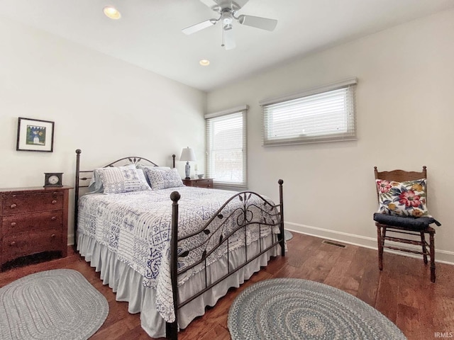 bedroom featuring ceiling fan, wood finished floors, visible vents, and baseboards