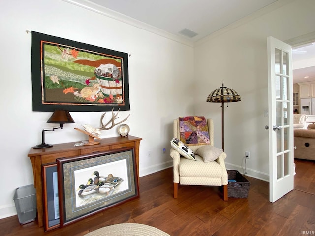 sitting room with baseboards, hardwood / wood-style floors, visible vents, and crown molding