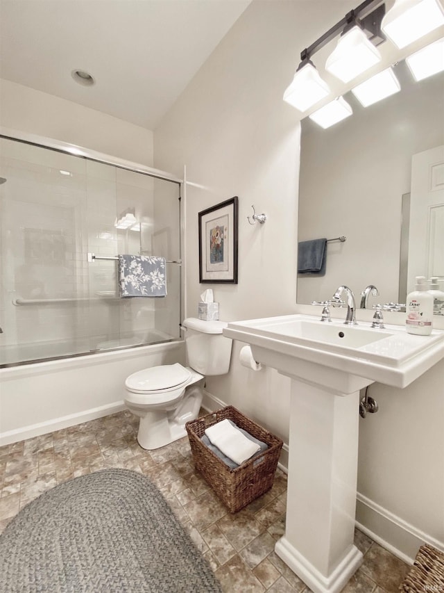 full bathroom featuring baseboards, shower / bath combination with glass door, and toilet