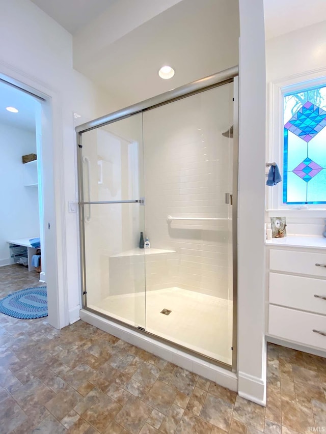 bathroom featuring a stall shower, stone finish flooring, and vanity