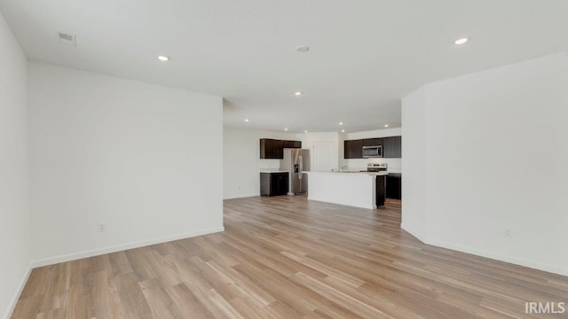 unfurnished living room with light wood-type flooring, visible vents, baseboards, and recessed lighting