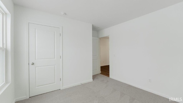 unfurnished bedroom with carpet flooring and baseboards