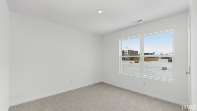 empty room with light carpet, visible vents, and baseboards