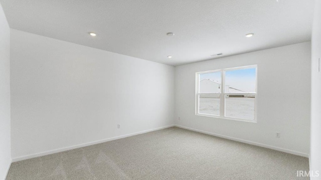 empty room with recessed lighting, visible vents, baseboards, and light colored carpet