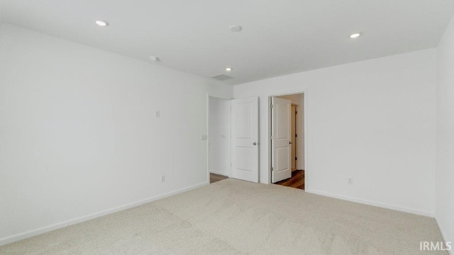 carpeted spare room with baseboards, visible vents, and recessed lighting