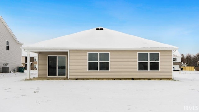 snow covered property with central AC