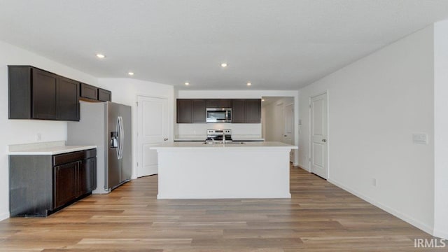 kitchen featuring light wood-type flooring, appliances with stainless steel finishes, and dark brown cabinets