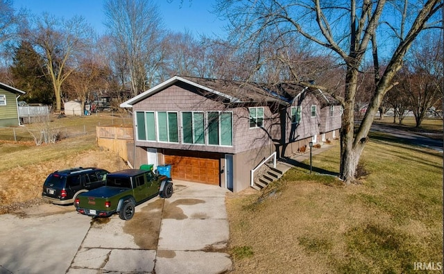 view of front facade with a front lawn, concrete driveway, a garage, and fence