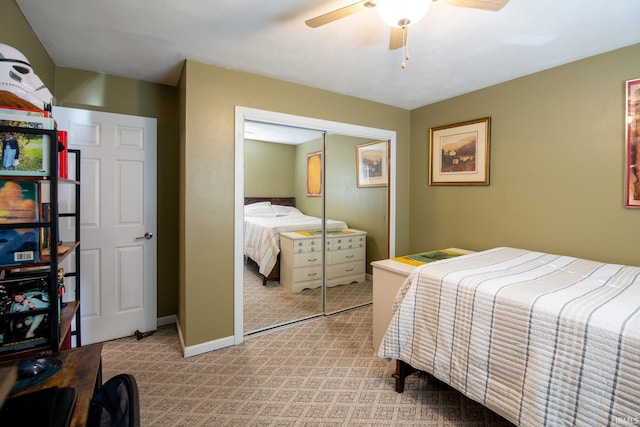 bedroom featuring light carpet, a ceiling fan, baseboards, and a closet