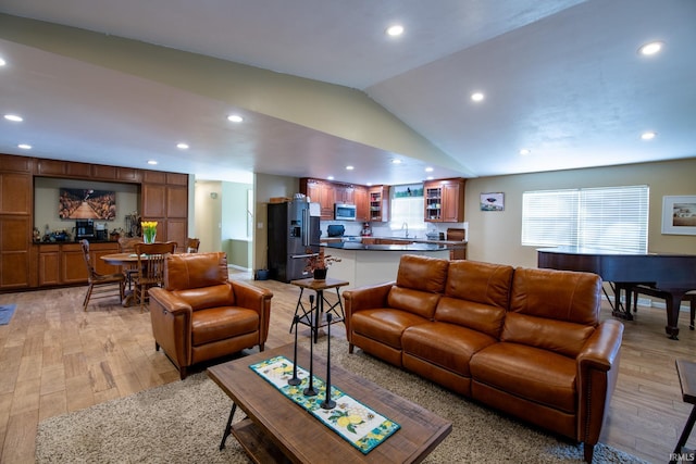 living room with lofted ceiling, light wood-style flooring, and recessed lighting