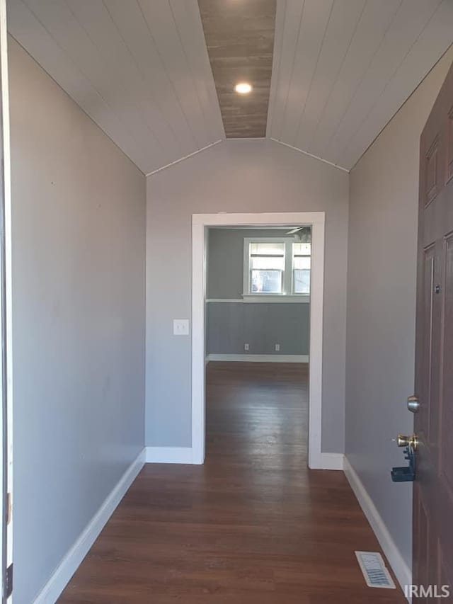 hallway featuring lofted ceiling, wood finished floors, visible vents, and baseboards