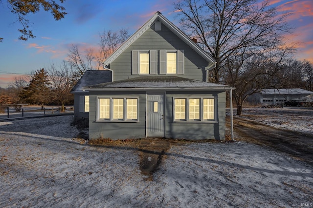 back of property at dusk with roof with shingles