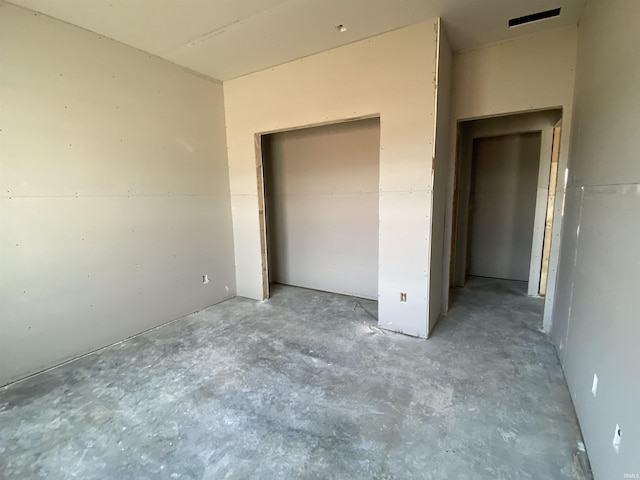 unfurnished bedroom featuring a closet and concrete floors