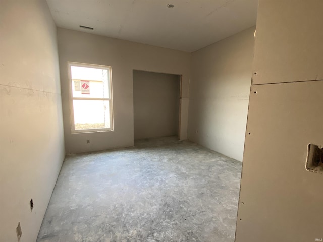 unfurnished bedroom with visible vents and concrete floors