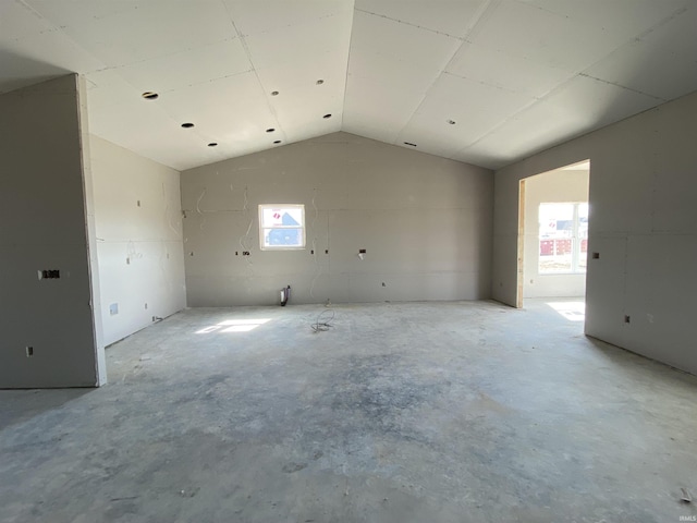 unfurnished room featuring vaulted ceiling and unfinished concrete flooring