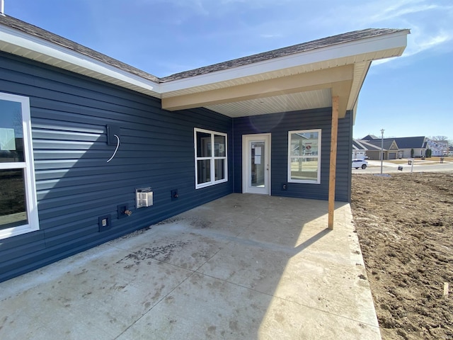 view of exterior entry with a patio