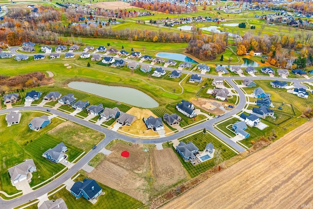 drone / aerial view featuring a residential view, golf course view, and a water view