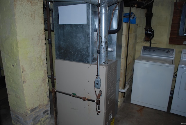 utility room with heating unit and washing machine and clothes dryer