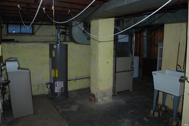 unfinished basement featuring a sink, washer / clothes dryer, and gas water heater