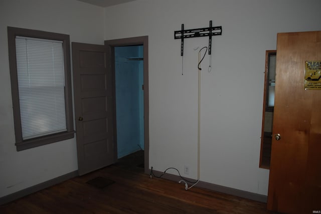 unfurnished room with baseboards and wood finished floors