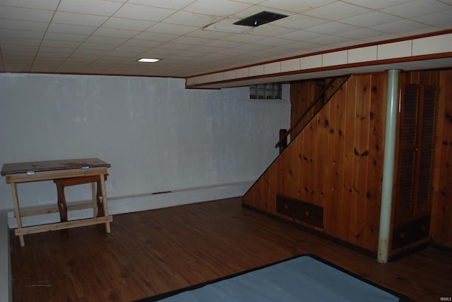 finished basement with wood finished floors and wooden walls