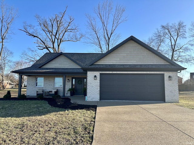 view of front of home featuring a garage, covered porch, brick siding, driveway, and a front yard