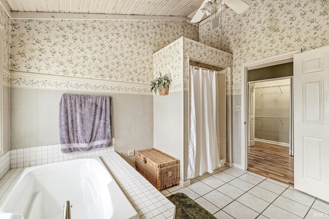 bathroom with vaulted ceiling, tile patterned flooring, a bath, and wallpapered walls