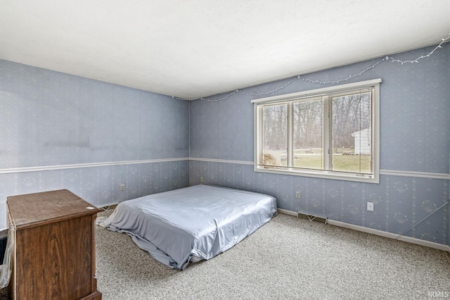 bedroom with baseboards, carpet floors, visible vents, and wallpapered walls