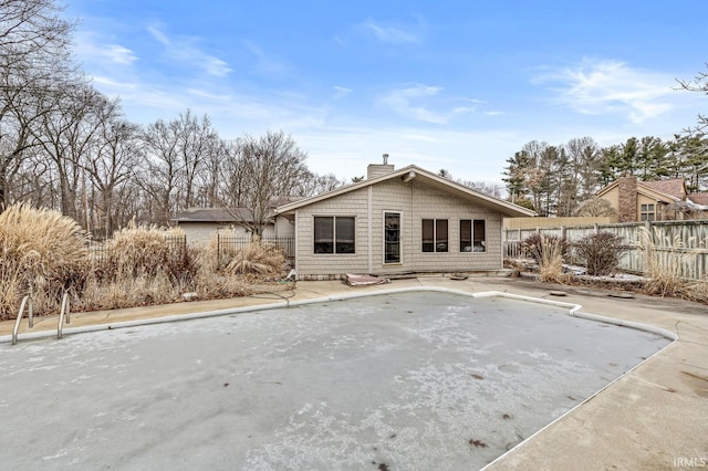 rear view of property with fence and a chimney