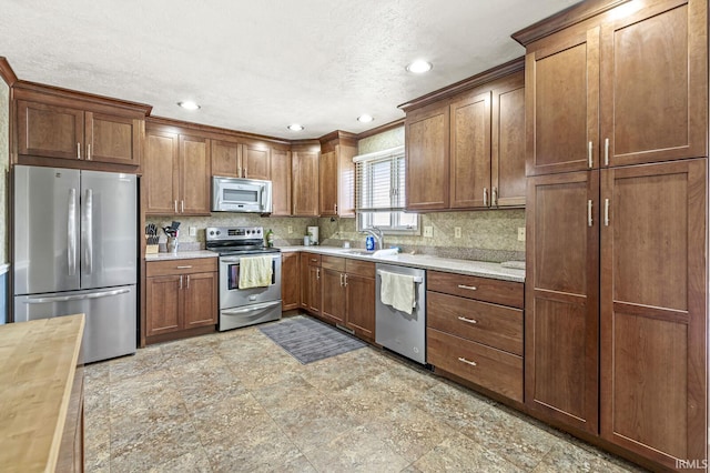 kitchen featuring tasteful backsplash, butcher block countertops, stainless steel appliances, a sink, and recessed lighting