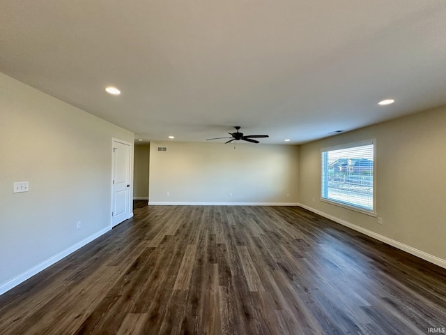 spare room with visible vents, baseboards, and dark wood-style flooring