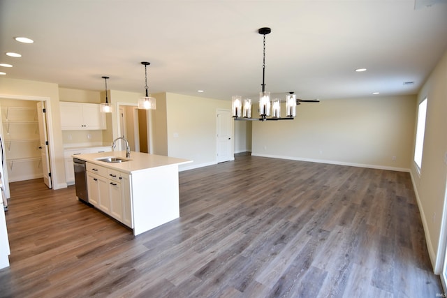 kitchen with light countertops, dark wood-style flooring, a sink, and white cabinets