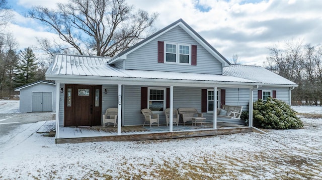 view of front of house with covered porch, metal roof, a storage unit, and an outdoor structure