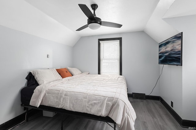 bedroom with lofted ceiling, ceiling fan, baseboards, and wood finished floors